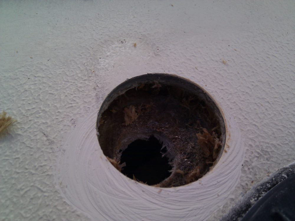 Durken har en gammal vattenskada. Vatten har läckt in i durken och distansmaterialet har ruttnat. Vilket dåligt arbete tidigare ägare har gjort: när man installerat fotstödstången har inte hålet tätats med epoxy.